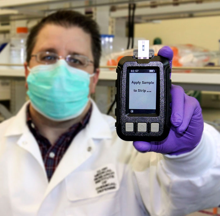 Dr. Shane Kasten holds the ruggedized prototype of his ChemDx test system