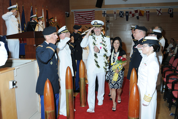 Capt. J. Christopher Daniel is "piped ashore" with his wife at the conclusion of his retirement ceremony