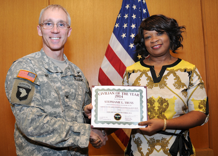 Col. Michael Wirt presents 2014 USAISR Civilian of the Year, Stephanie Truss, with a certificate