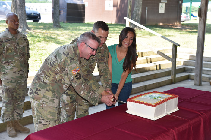 Col. Derek C. Cooper cuts a commemorative cake