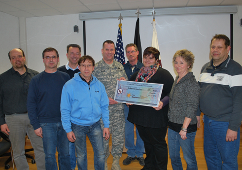 Col. Thomas C. Slade, USAMMCE commander, presents a donation check to Simone Jennewein of a local hospice.