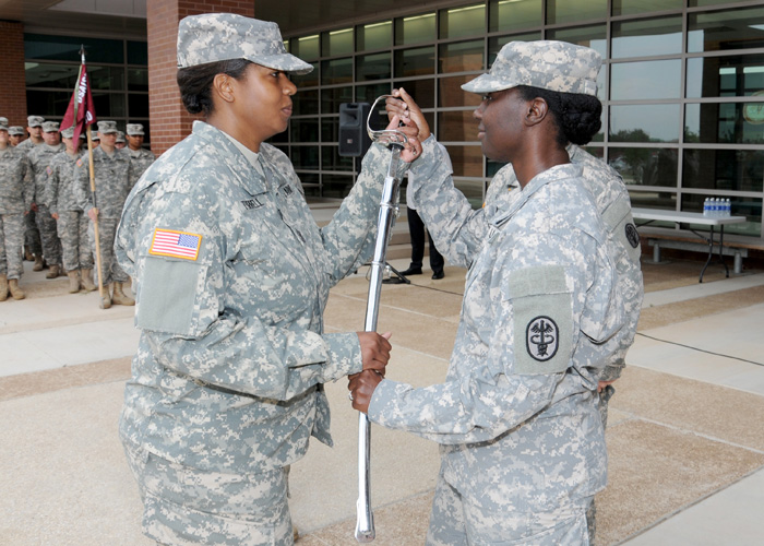 1st Sgt. Natasha A. Turrell (left) accepts the noncommissioned officer's sword from Capt. LaShawnna Ray (right)