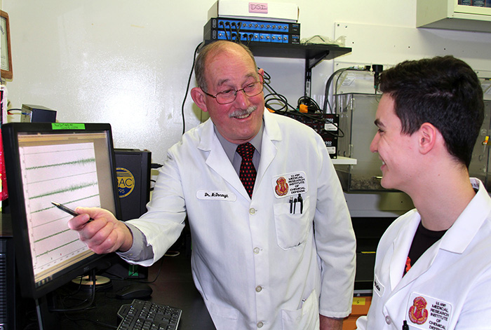 Dr. John H. McDonough discusses brain wave data from a test of an anticonvulsant drug with Sergiu Costinas