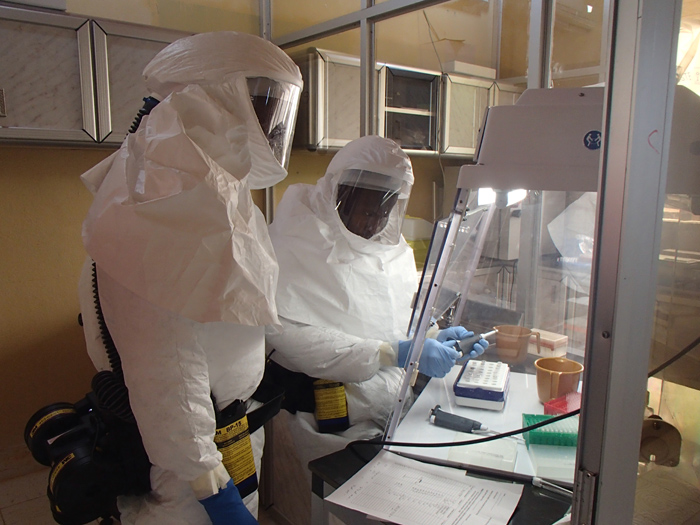 Technicians set up an assay test for Ebola within the USAMRIID containment laboratory.