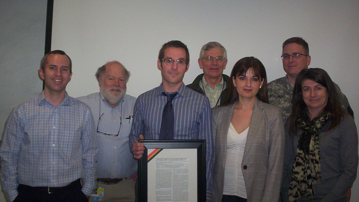 Dr. Jason Koontz successfully defends his thesis and is presented with a framed copy of his first authored work
