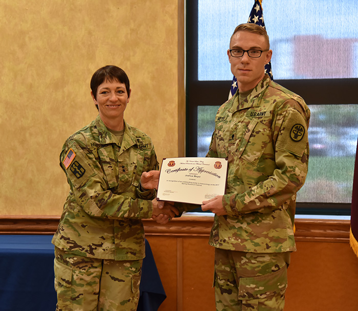 Maj. Gen. Barbara R. Holcomb presents Spec. Joshua Meyer with this award