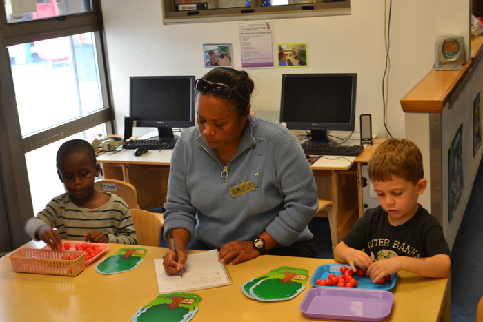 Child Development Center students Aleister and Aaron sort shapes into groups under Teacher Valerie Woodward's close supervision.