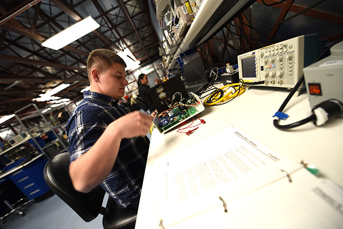 Engineering technician Tyler Dowell works on a piece of equipment