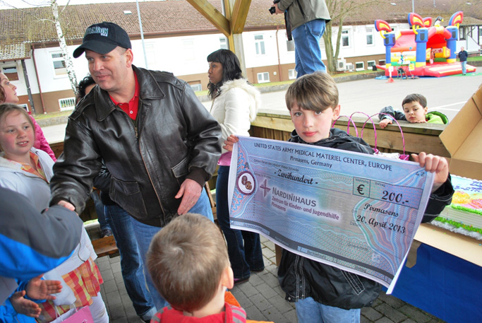 Col. Thomas C. Slade, presents a check for 200 Euros (approximately $260 US) to the Nardinihaus orphanage
