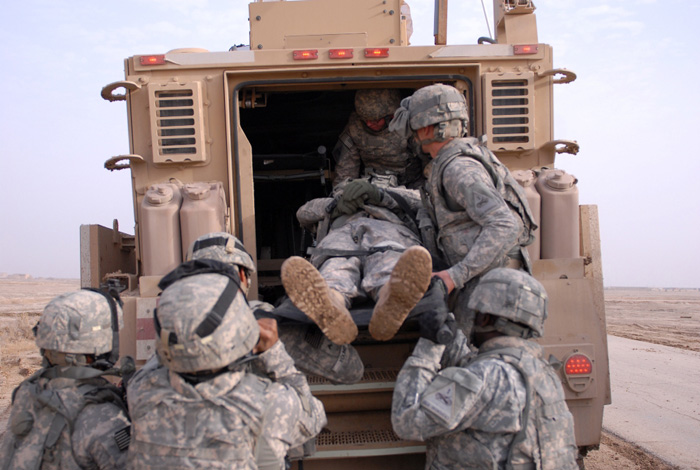 Loading a casualty into the back of an MRAP MaxxPro ambulance
