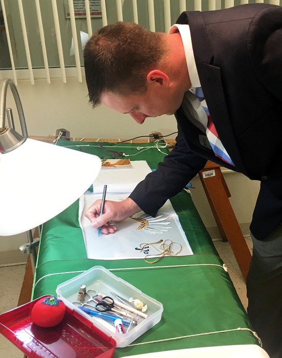 Knighten signs the inside of a flag being sewn for the next president