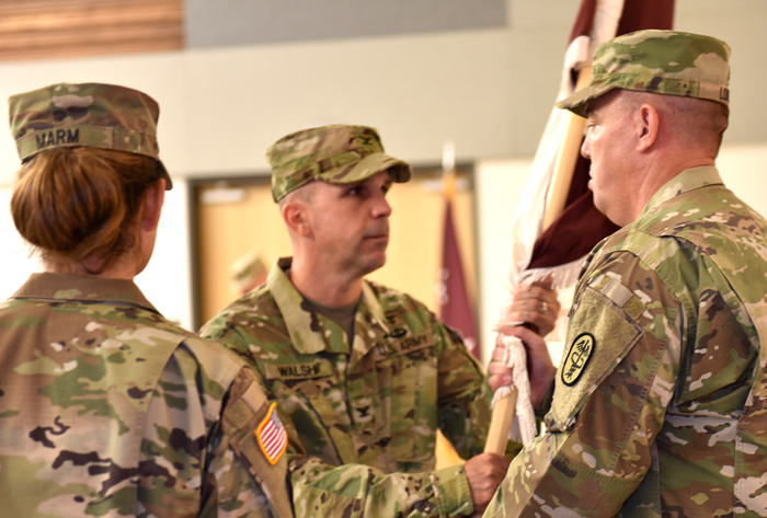 Col. Timothy Walsh passes the colors to Sgt. Maj. Corey Lord